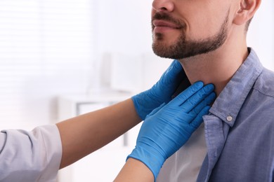 Photo of Doctor examining thyroid gland of patient in hospital, closeup