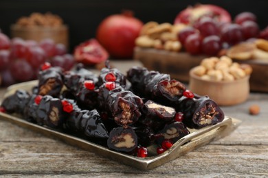 Tray with delicious sweet churchkhelas on wooden table, closeup