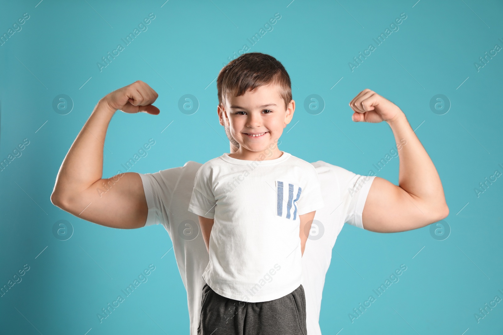 Photo of Portrait of sporty dad and his son on color background