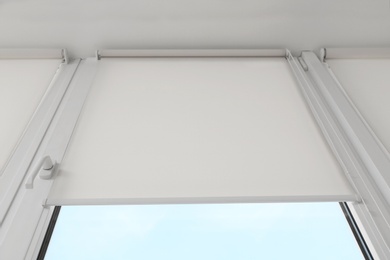 Photo of Window with modern roll blinds in room, closeup