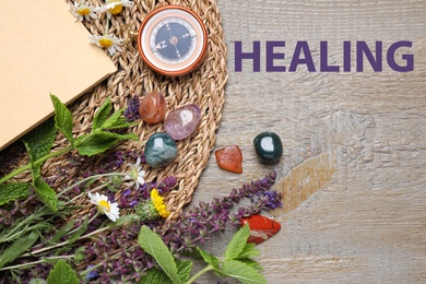Image of Flat lay composition with different gemstones and healing herbs on wooden table 