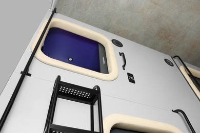 Photo of Capsule in modern pod hostel, low angle view
