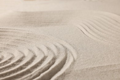 Photo of Beautiful lines drawn on sand, closeup. Zen garden
