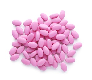 Tasty pink dragee candies on white background, top view