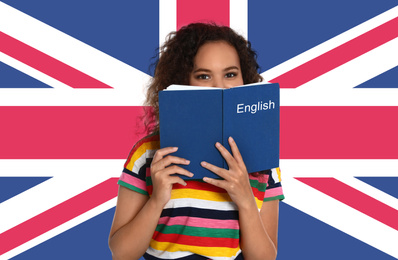 Image of Beautiful African-American girl with book and flag of Great Britain as background. Learning English