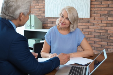 Senior notary working with client in office