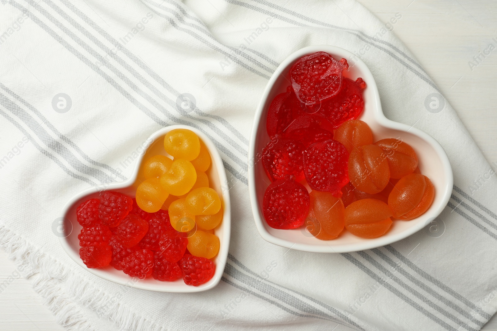 Photo of Delicious gummy fruit shaped candies on table, flat lay