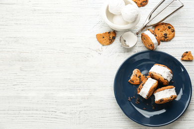 Photo of Sweet delicious ice cream cookie sandwiches served on white wooden table, flat lay. Space for text