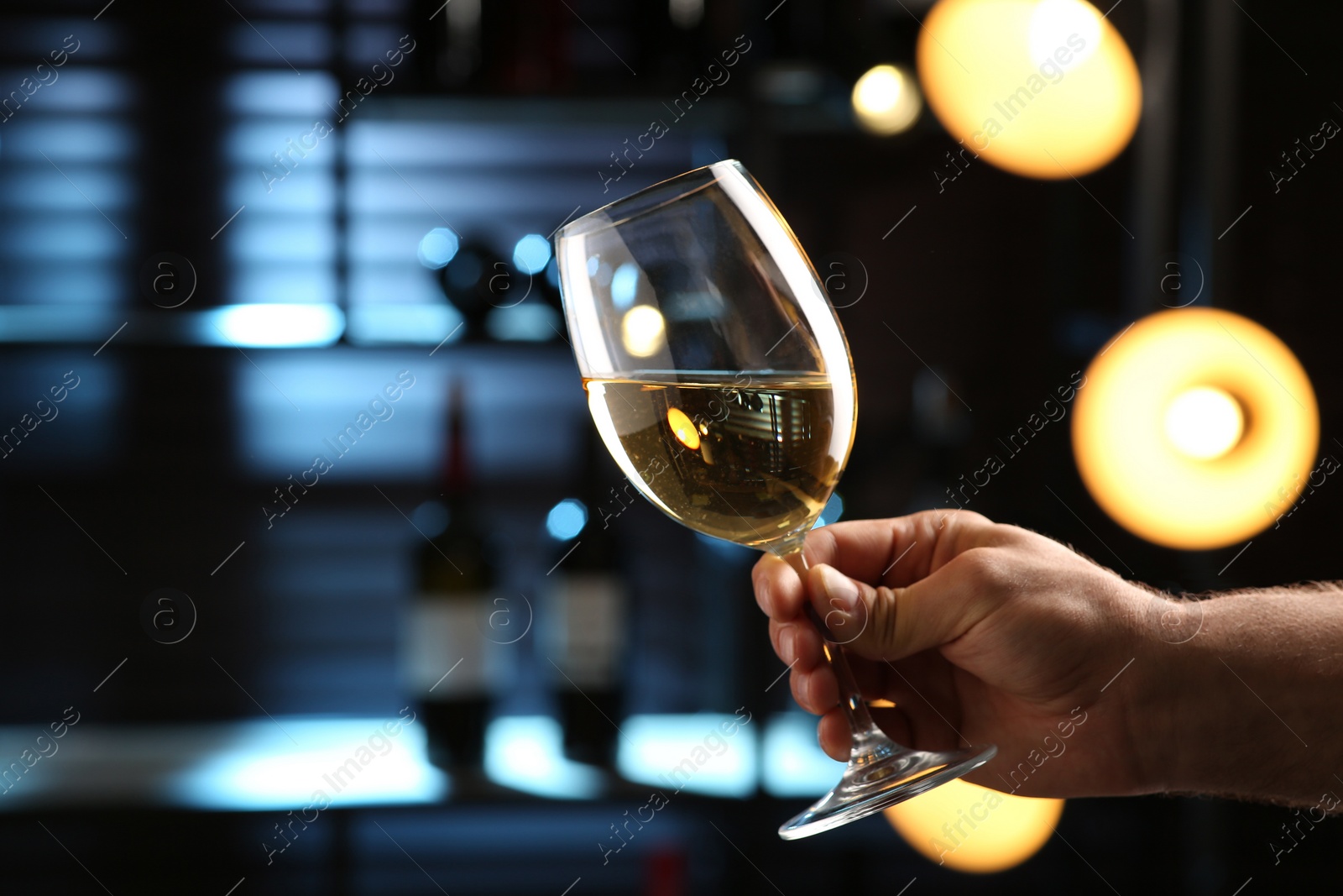 Photo of Man with glass of white wine indoors, closeup. Space for text