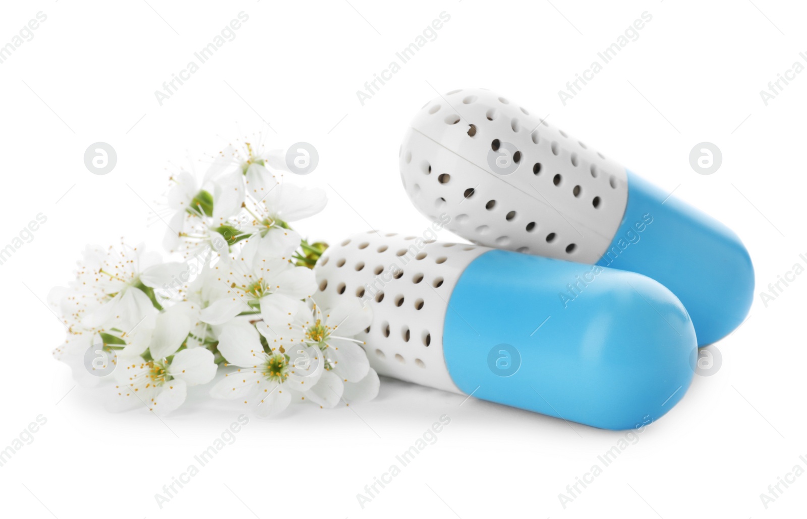 Photo of Capsule shoe fresheners and flowers on white background