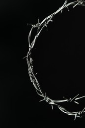 Photo of Shiny metal barbed wire on black background