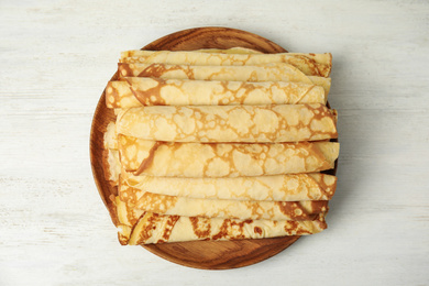 Fresh thin pancakes on white wooden table, top view