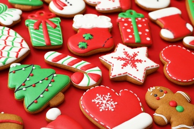 Different Christmas gingerbread cookies on red background, closeup