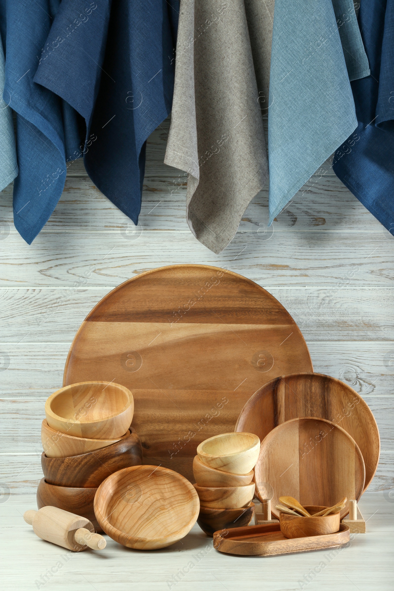 Photo of Set of clean wooden dishware and utensils on table