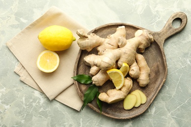 Photo of Fresh lemons and ginger on grey marble table, flat lay