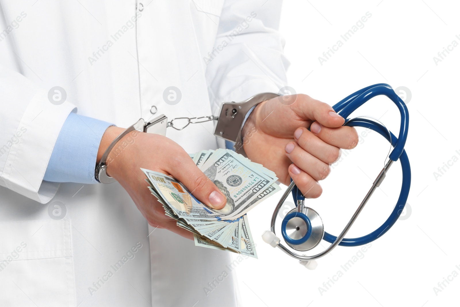 Photo of Doctor in handcuffs with bribe and stethoscope on white background, closeup. Corrupted medicine