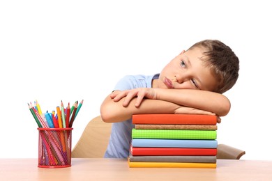 Photo of Little boy with stationery and stack of books suffering from dyslexia at wooden table