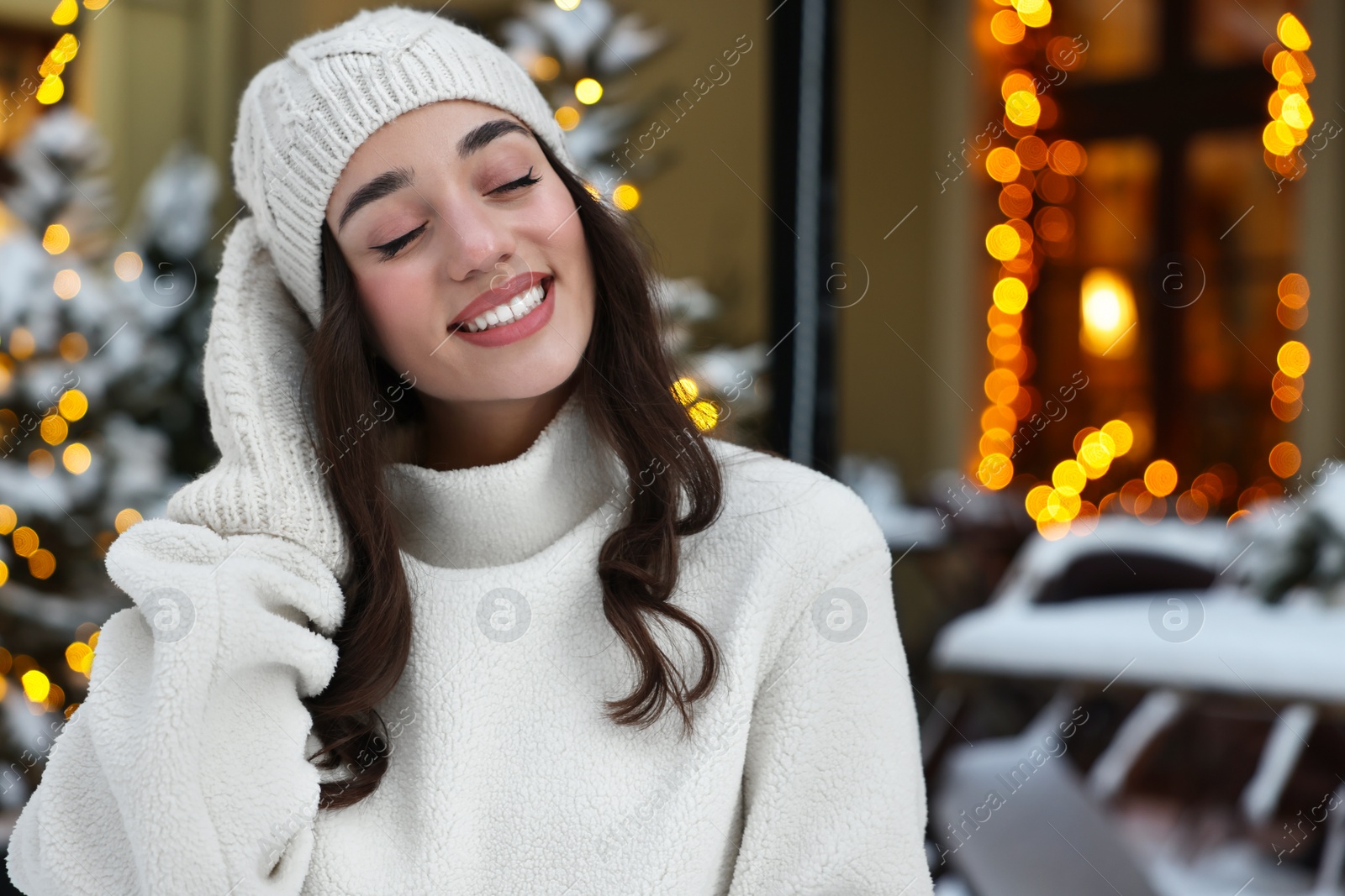 Photo of Portrait of smiling woman on city street in winter. Space for text