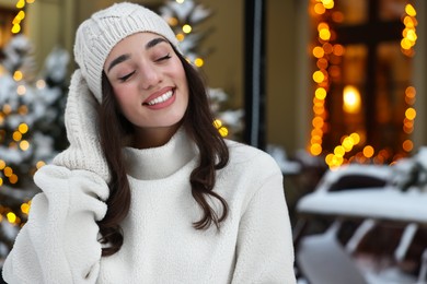 Photo of Portrait of smiling woman on city street in winter. Space for text