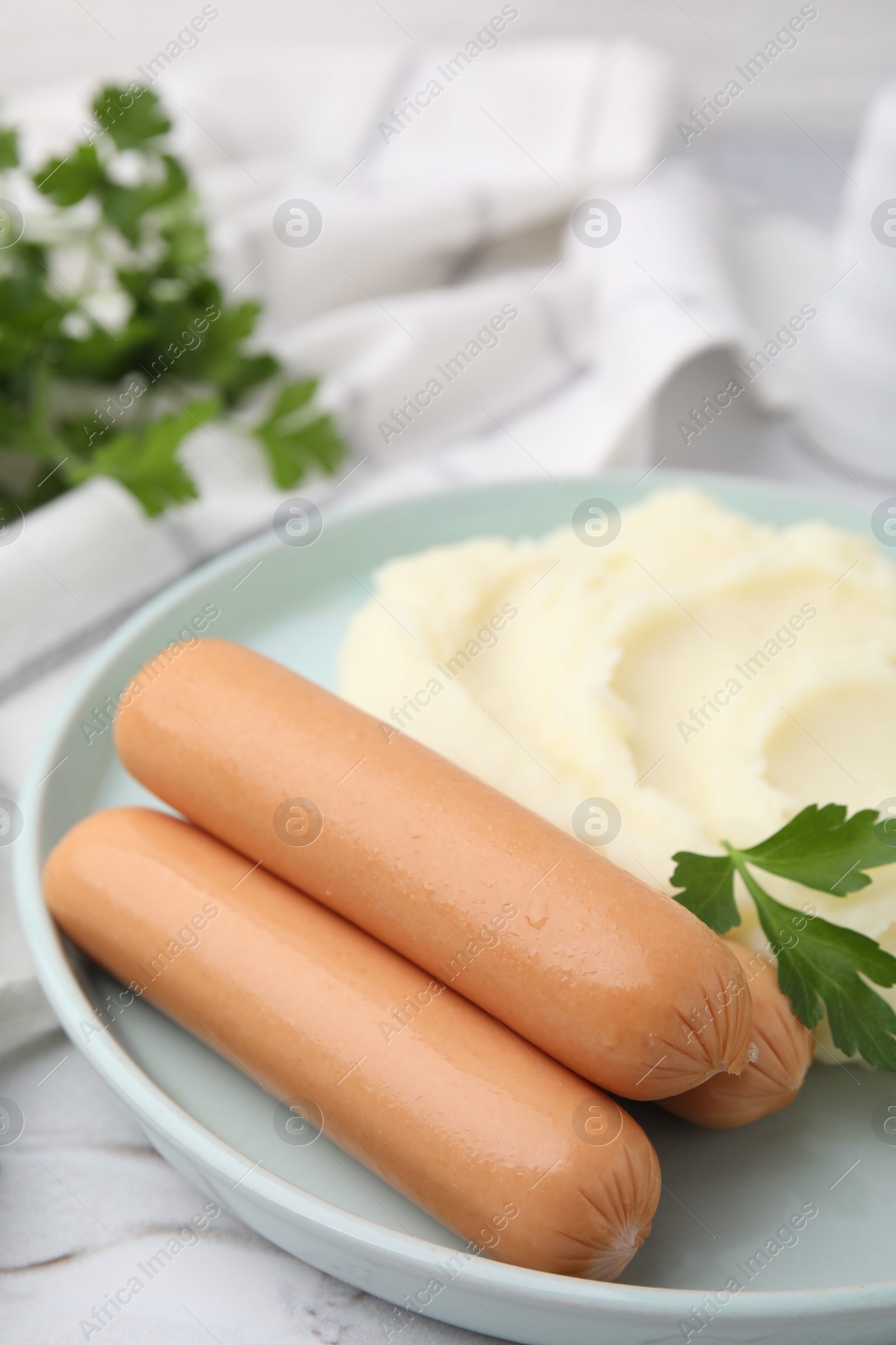 Photo of Delicious boiled sausages, mashed potato and parsley on table, closeup