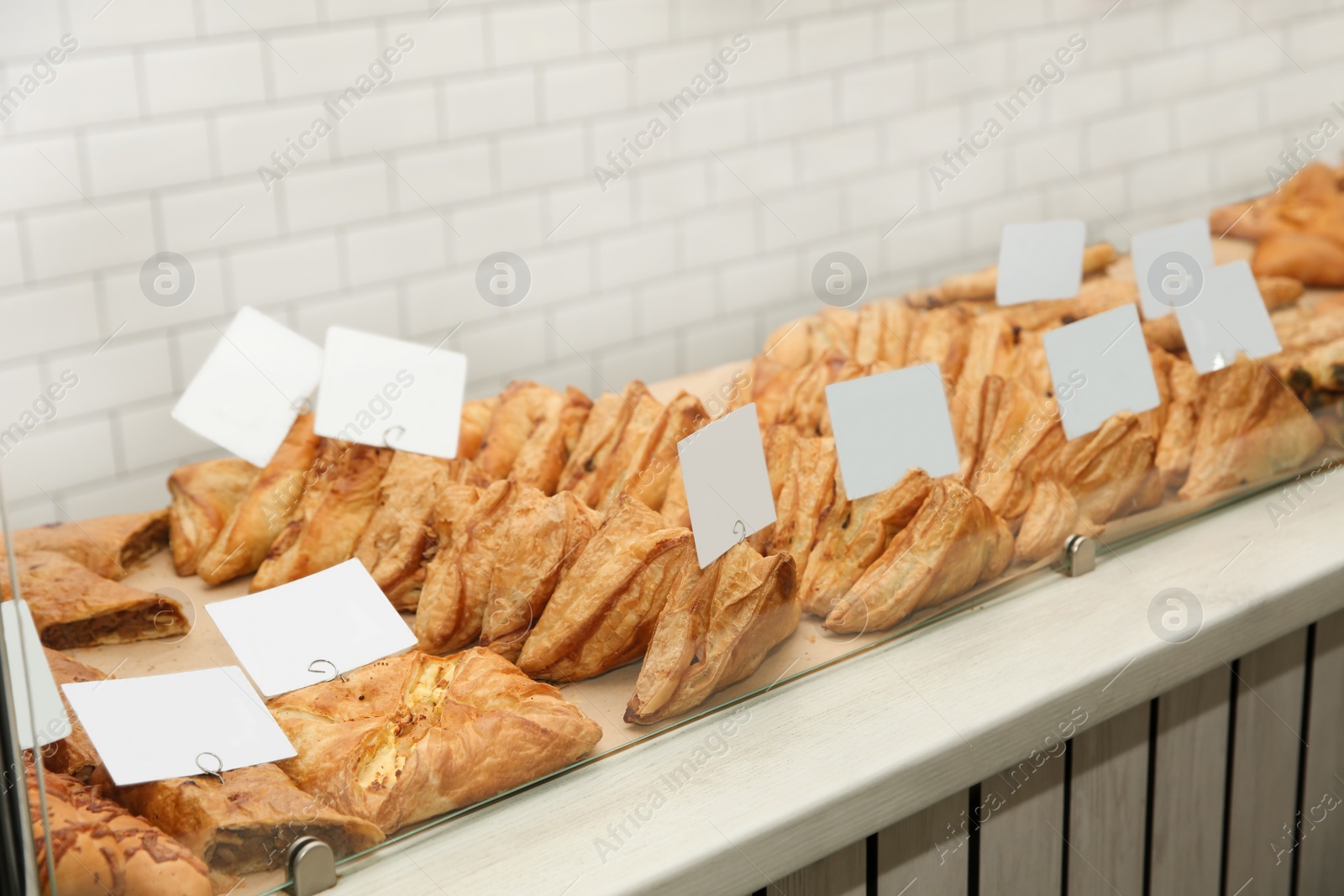 Photo of Fresh pastries on counter in bakery store. Space for text