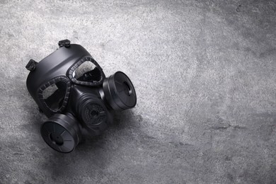 One gas mask on grey textured background, top view. Space for text