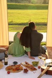 Romantic date. Couple spending time together during picnic on sunny day, back view