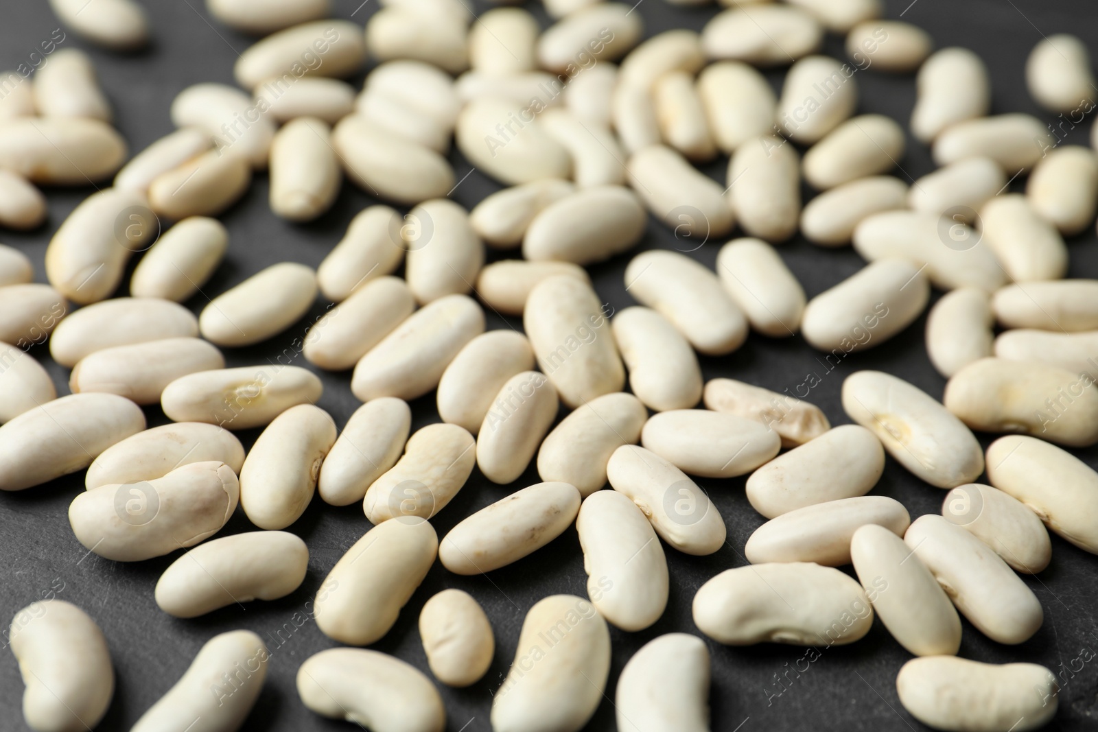 Photo of Raw beans on black background, closeup. Vegetable seeds