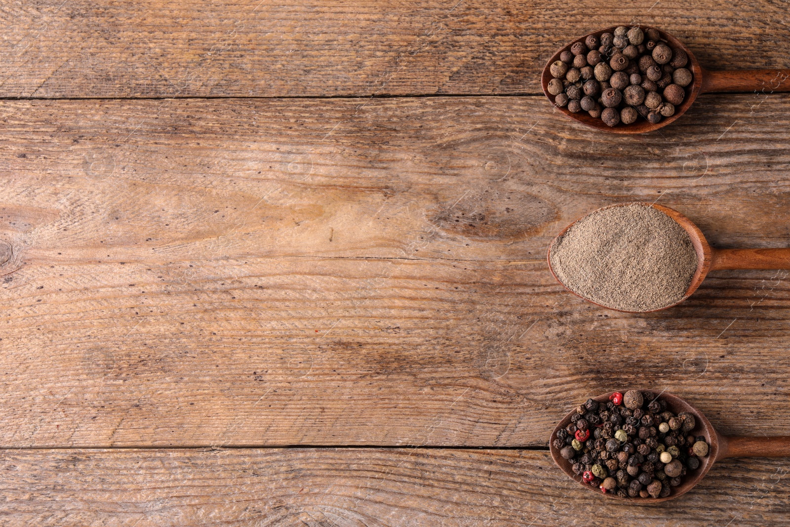 Photo of Different peppers on wooden table, flat lay. Space for text