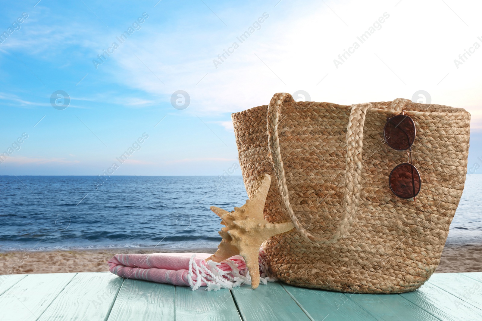 Image of Beach accessories on turquoise wooden surface near sea, space for text