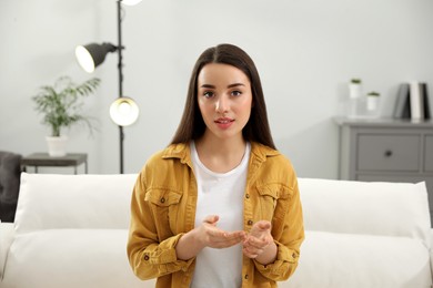 Photo of Young woman conducting webinar in room at home
