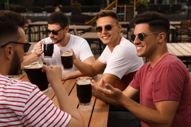 Friends with glasses of beer in outdoor cafe