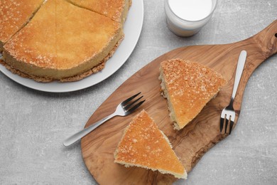 Photo of Tasty cut sponge cake on grey table, flat lay