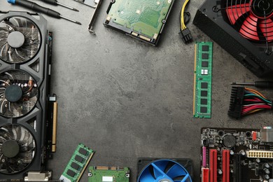 Photo of Frame of graphics card and other computer hardware on grey textured table, flat lay. Space for text