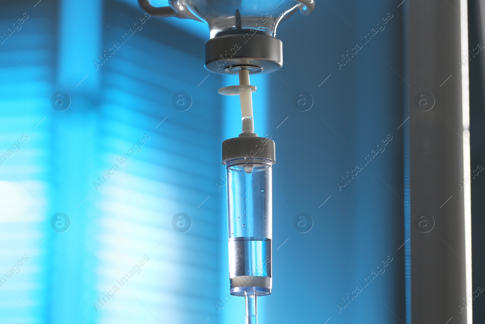 Photo of IV drip against blurred light blue background