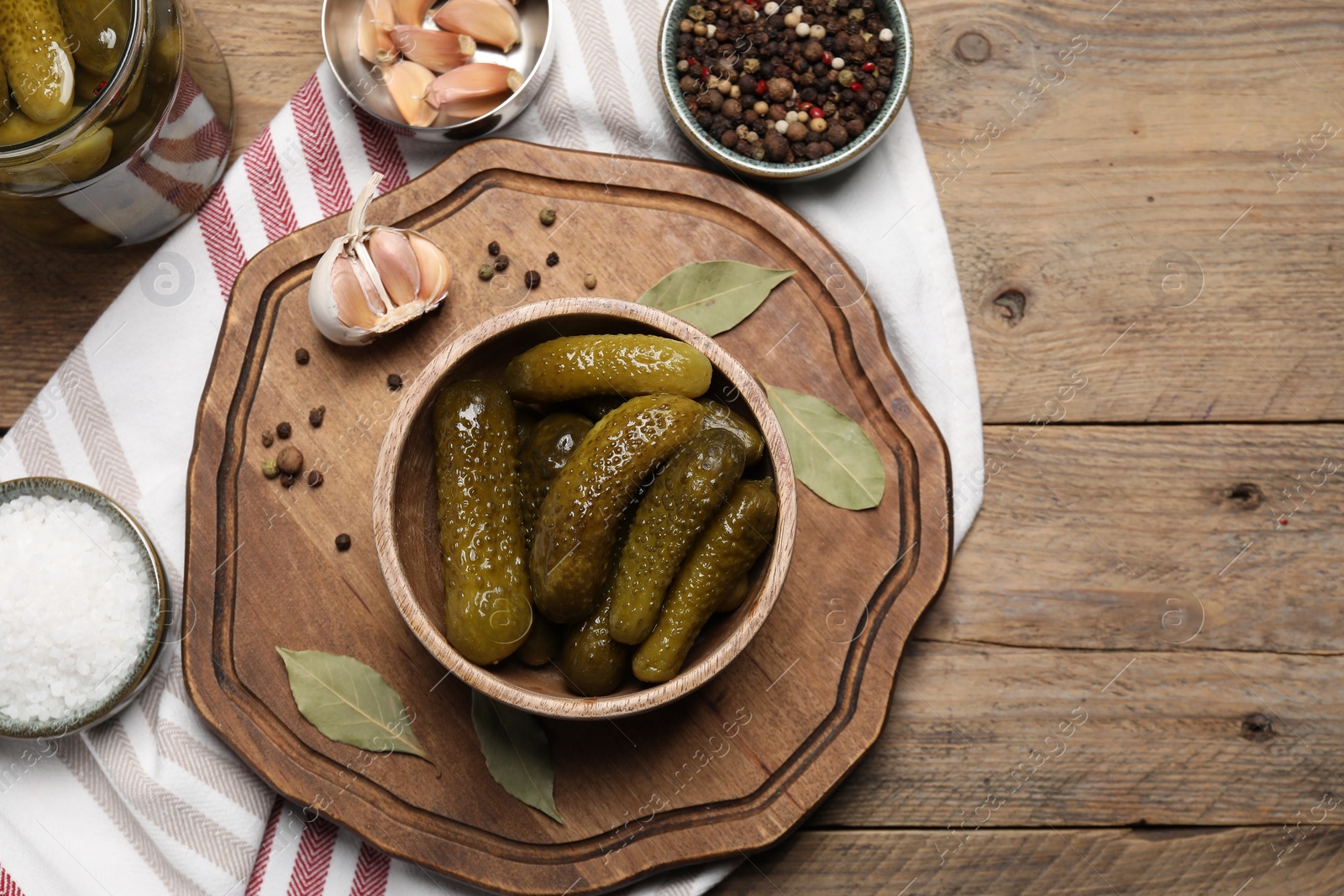 Photo of Tasty pickled cucumbers and spices on wooden table, flat lay. Space for text