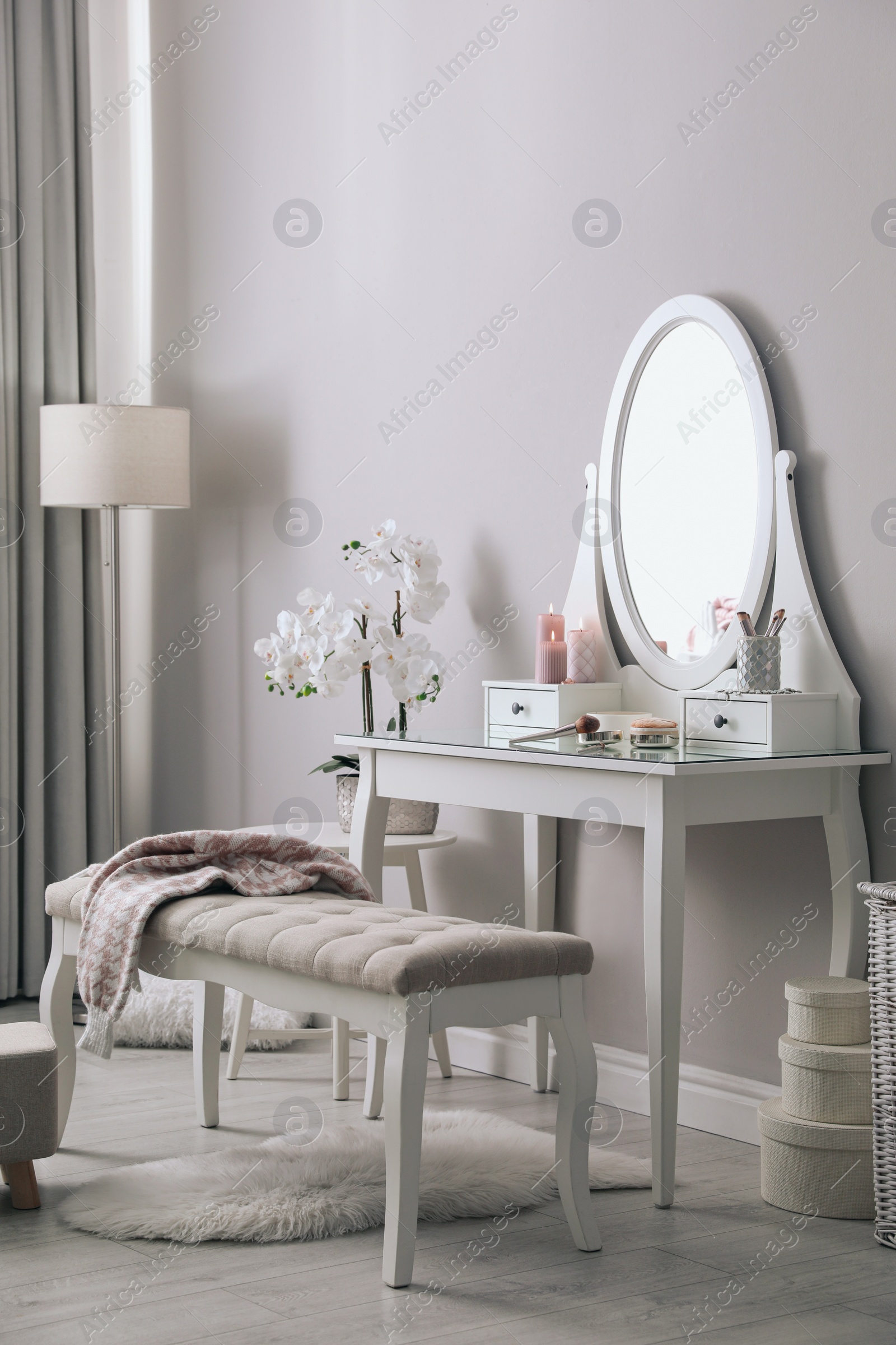 Photo of Wooden dressing table with decorative elements and makeup products in room. Interior design