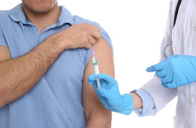 Photo of Doctor giving injection to patient on white background, closeup. Vaccination concept
