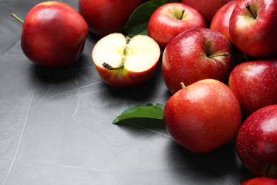 Photo of Ripe juicy red apples on grey table, closeup