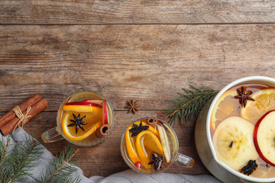 Photo of Aromatic mulled wine on wooden table, flat lay. Space for text