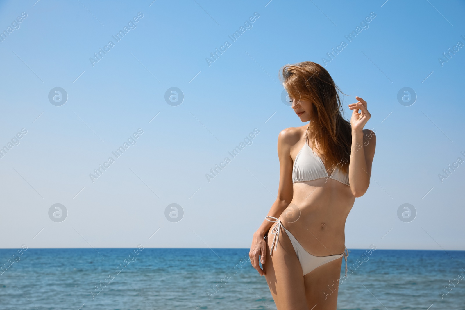 Photo of Attractive woman with perfect body in bikini near sea