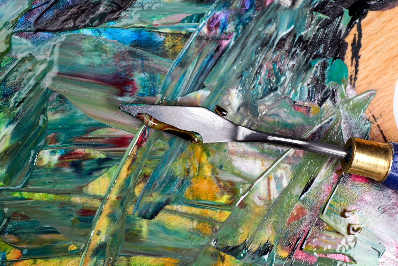Photo of Abstract colorful acrylic paint and spatula, top view
