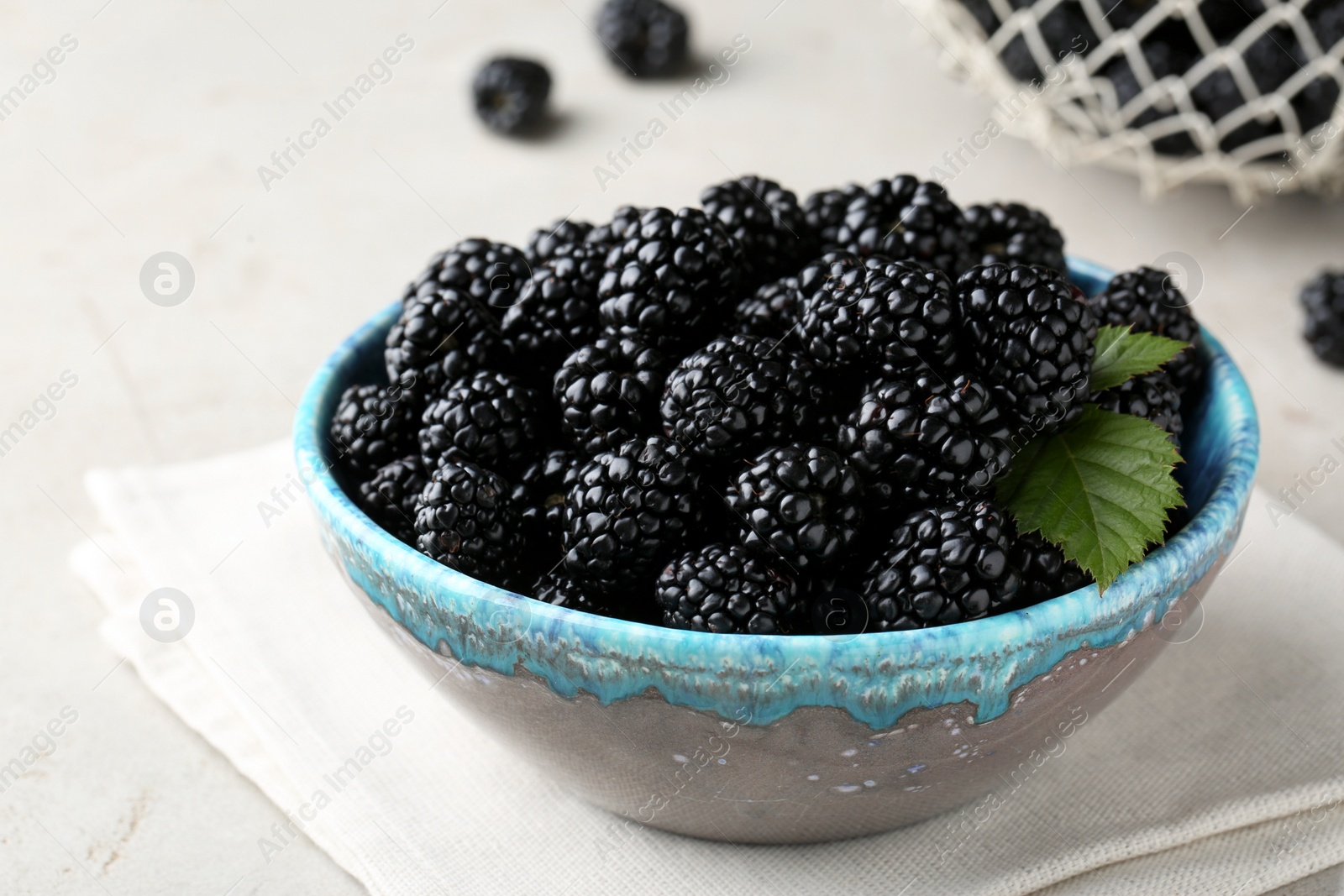 Photo of Tasty ripe blackberries in bowl on table