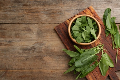 Photo of Fresh green sorrel leaves on wooden table, flat lay. Space for text