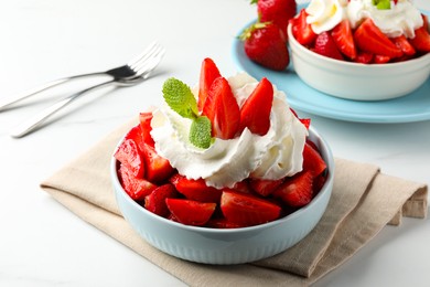 Photo of Delicious strawberries with whipped cream served on white table