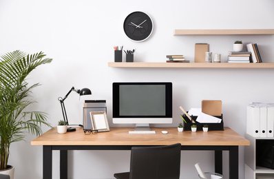 Photo of Modern computer on table in office interior. Stylish workplace