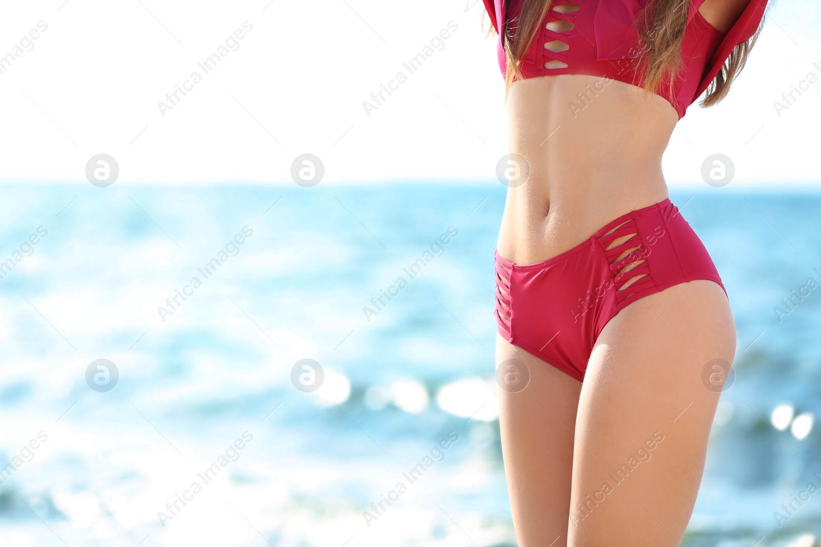 Photo of Attractive young woman in beautiful bikini swimsuit on beach, closeup