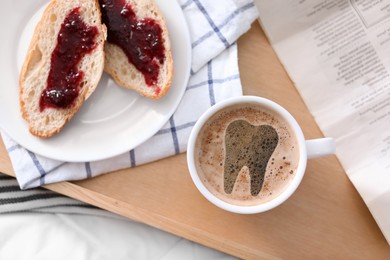 Coffee causing dental problem. Cup of hot drink on wooden tray, flat lay