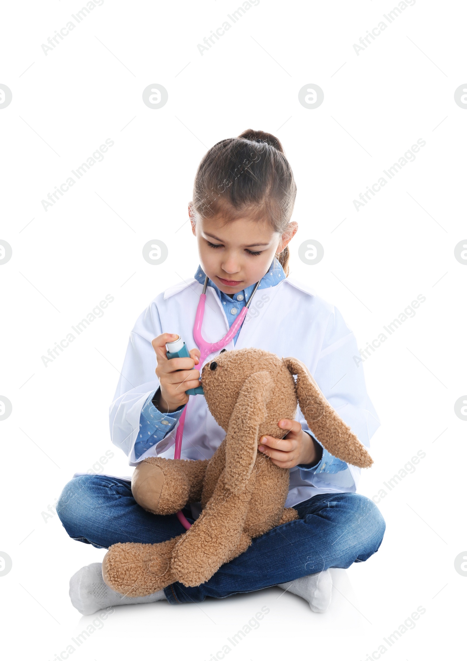 Photo of Cute child playing doctor with stuffed toy on white background