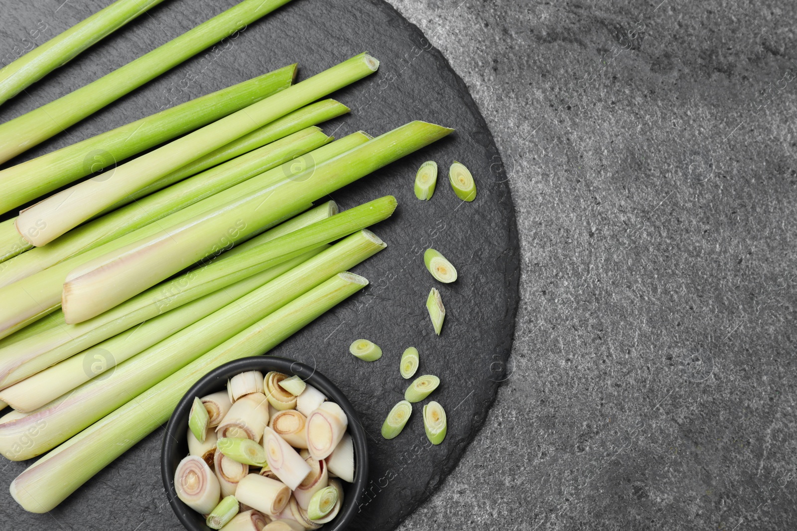 Photo of Fresh lemongrass stalks on grey table, top view. Space for text